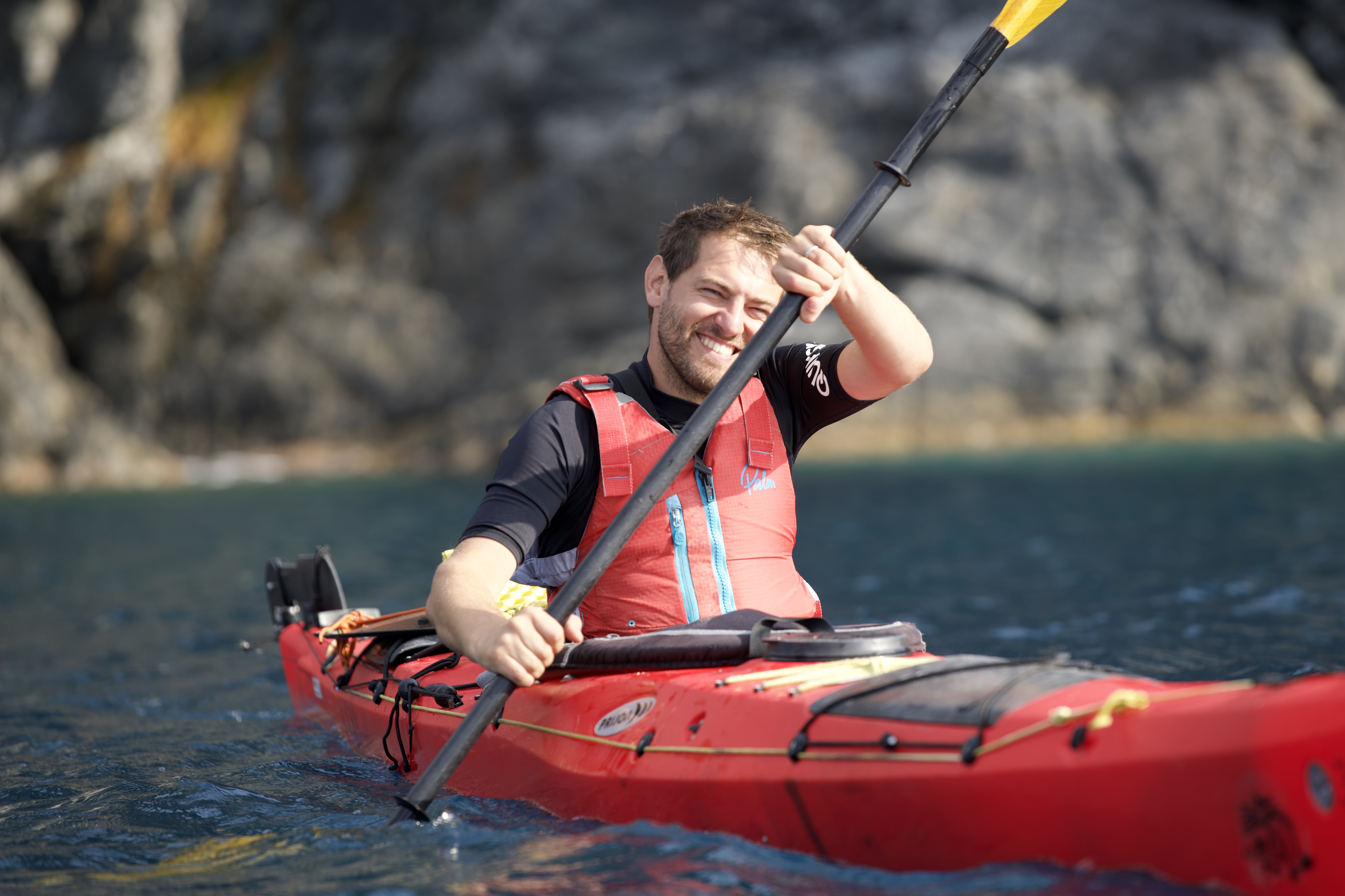 Andreas Frey im Kajak auf dem Wasser, lächelnd mit Paddel in der Hand